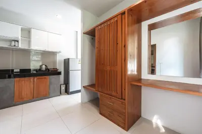 a kitchen with wooden cabinets and a refrigerator at Little Kamala Hill in Kamala Beach