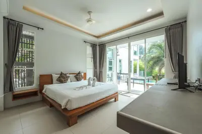 a bedroom with a bed and a flat screen tv at Little Kamala Hill in Kamala Beach