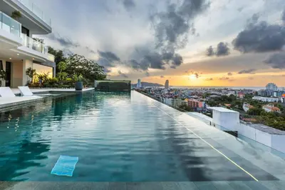 a swimming pool on top of a building with a sunset at 
