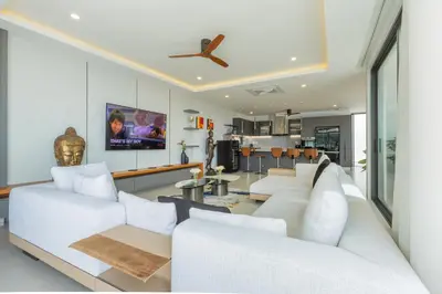 a living room with white furniture and a ceiling fan at 