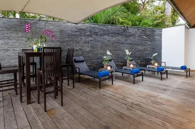 a patio with chairs and tables and a brick wall at 28 - Sea View Luxury Pool Villa in Phuket Town