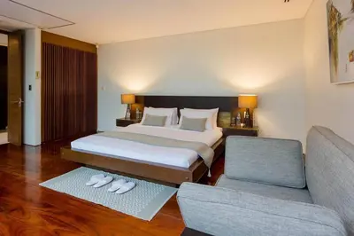 a bedroom with a bed and two chairs and a couch at 28 - Sea View Luxury Pool Villa in Phuket Town