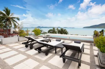 a patio with a table and chairs next to a pool at Serenity Rawai by Destada in Rawai Beach
