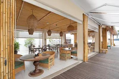 a restaurant with tables and chairs on a deck at Serenity Rawai by Destada in Rawai Beach