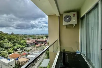 a balcony with a clock on the side of a building at Chic Condominium Karon B511 in Karon Beach