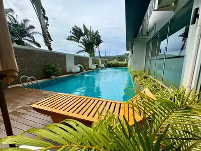 a swimming pool with a wooden bench next to a building at Chic Condominium Karon B511 in Karon Beach