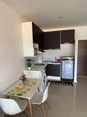 a kitchen with a table and chairs and a stove at Chic Condominium Karon B307 in Karon Beach