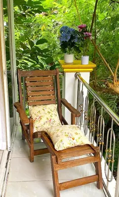 a wooden chair sitting on a porch with a table at BOUTIQUE-VILLA with Suites & Rooms in Karon Beach