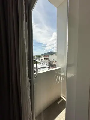 an open door to a balcony with a view at Chill-long inn in Ban Klang