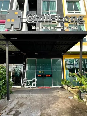 a building with a bench sitting in front of it at Chill-long inn in Ban Klang