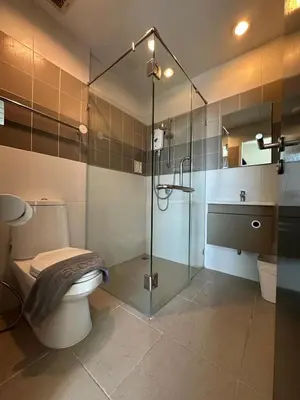 a bathroom with a toilet and a glass shower at Chill-long inn in Ban Klang