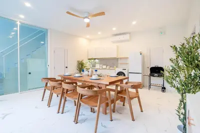 a kitchen and dining room with a wooden table and chairs at Seven Heaven Patong Villa in Patong Beach