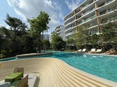a swimming pool in front of a large building at Phyll Phuket - Luxury Resort-Style Comfort in Ban Rangeng