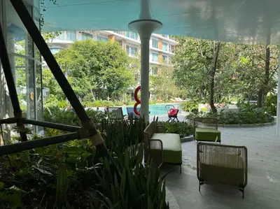 a patio with chairs and a pool in a building at Phyll Phuket - Luxury Resort-Style Comfort in Ban Rangeng