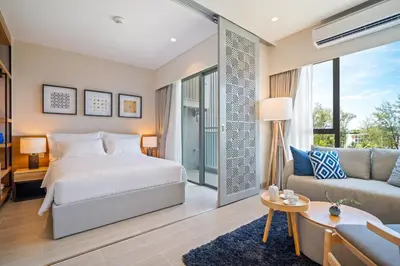 a bedroom with a bed and a couch at Laguna Lakeside Residences by Banyan Living in Laguna Phuket