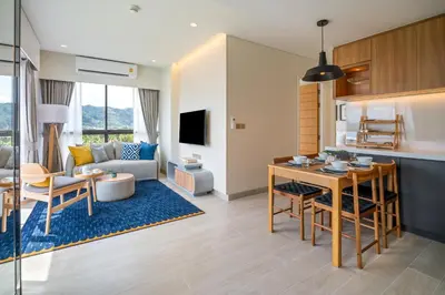 a kitchen and a living room with a table at Laguna Lakeside Residences by Banyan Living in Laguna Phuket