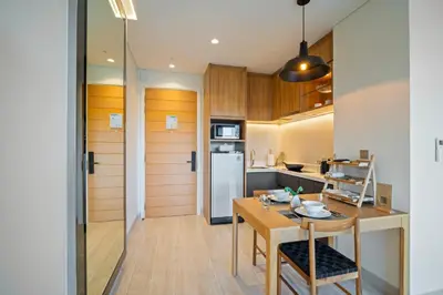 a small kitchen with a wooden table and a dining room at Laguna Lakeside Residences by Banyan Living in Laguna Phuket