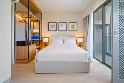 a bedroom with a large bed and a tv at Laguna Lakeside Residences by Banyan Living in Laguna Phuket