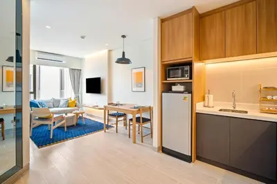 a kitchen and a living room with a table at Laguna Lakeside Residences by Banyan Living in Laguna Phuket