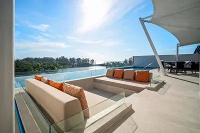 a patio with a couch and a table and chairs at Angsana Oceanview Residences in Laguna by Banyan Living in Laguna Phuket