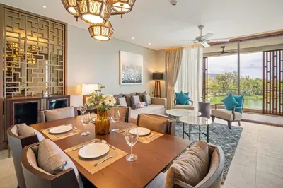 a dining room with a table and a living room at Angsana Oceanview Residences in Laguna by Banyan Living in Laguna Phuket