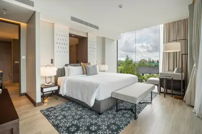 a bedroom with a large bed and a large window at Angsana Oceanview Residences in Laguna by Banyan Living in Laguna Phuket