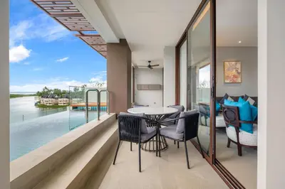 a room with a balcony with a table and chairs at Angsana Oceanview Residences in Laguna by Banyan Living in Laguna Phuket