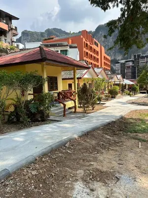 a street in a city with buildings and a bench at อดัมบังกะโล in Ao Nang Beach