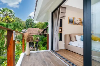 a bedroom with a view of the garden from the balcony of a house at patong hill villa 3 in Patong Beach