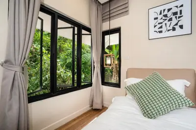 a bedroom with a bed and large windows at patong hill villa 3 in Patong Beach