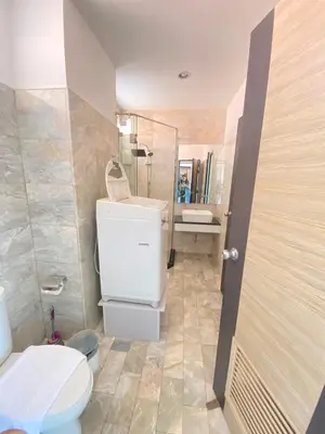 a bathroom with a toilet and a sink and a mirror at Stunning 60 sqm Studio at NaiHarn Beach Condo, Walk to Beach, Your Tropical Retreat! in Rawai Beach