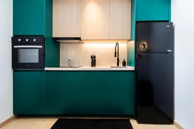 a kitchen with green cabinets and a black refrigerator at 5BR Modern Luxury Pool Villa Patong TPSV140 in Patong Beach