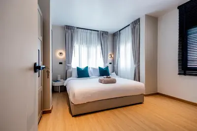 a bedroom with a bed with blue pillows and a window at 5BR Modern Luxury Pool Villa Patong TPSV140 in Patong Beach