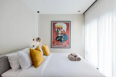 a bedroom with a large white bed with yellow pillows at 5BR Modern Luxury Pool Villa Patong TPSV140 in Patong Beach