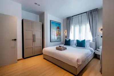 a bedroom with a large white bed with blue pillows at 5BR Modern Luxury Pool Villa Patong TPSV140 in Patong Beach