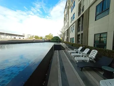 a swimming pool with lounge chairs next to a building at Zcape Condotel Bangtao Beach in Bang Tao Beach