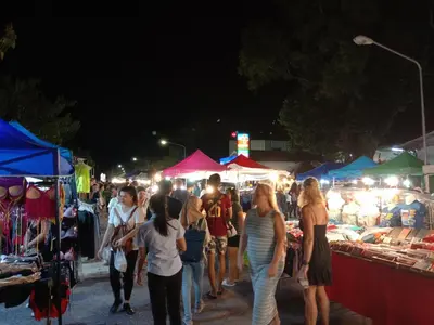 a group of people walking around a market at night at Zcape Condotel Bangtao Beach in Bang Tao Beach