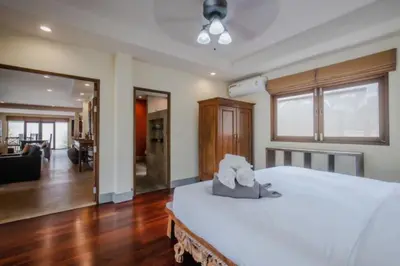 a bedroom with a large white bed and a living room at NEW Phuket Residence 2 Bedrooms Charming House in Rawai Beach
