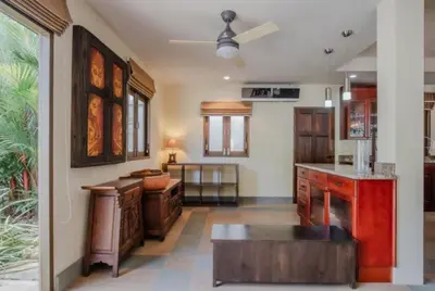 a large kitchen with wooden cabinets and a table at NEW Phuket Residence 2 Bedrooms Charming House in Rawai Beach
