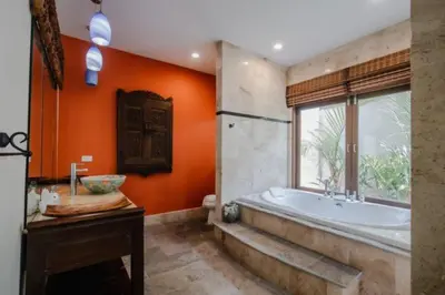 an orange bathroom with a tub and a window at NEW Phuket Residence 2 Bedrooms Charming House in Rawai Beach