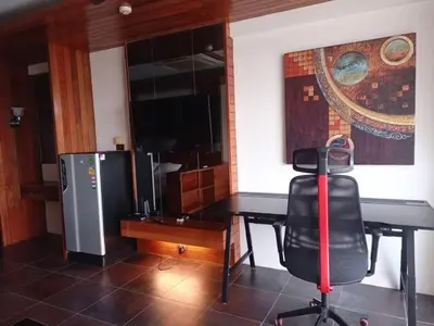 a room with a desk and a refrigerator and a chair at The green golf resident in Kathu
