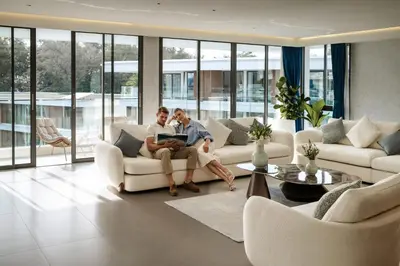 two people sitting on a couch in a living room at Kora Beach Resort Phuket in Bang Tao Beach
