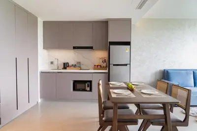 a kitchen and dining room with a table and chairs at Kora Beach Resort Phuket in Bang Tao Beach