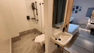 a bathroom with a sink and a shower at IHOC - Phuket OldTown in Ban Lo Long