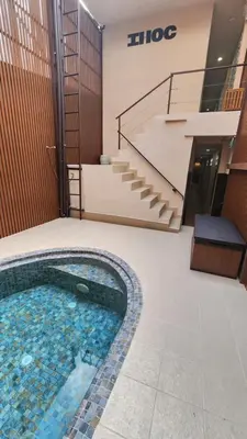 a swimming pool in the middle of a building with stairs at IHOC - Phuket OldTown in Ban Lo Long