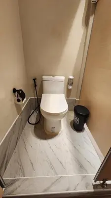 a bathroom with a white toilet in a room at IHOC - Phuket OldTown in Ban Lo Long