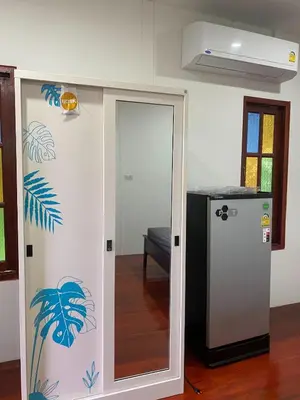 a room with a sliding door with a refrigerator at thechalethome in Panwa Beach
