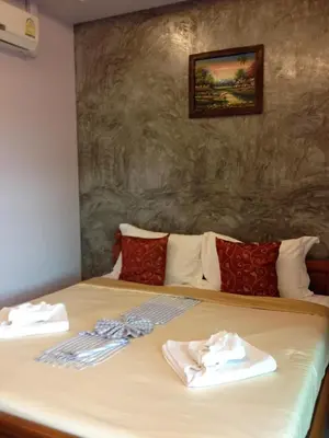 a bed with two towels sitting on top of it at Pennapa Chalet in Chalong