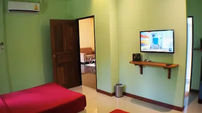 a room with a mirror and a door and a television at Pennapa Chalet in Chalong
