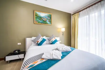 a bedroom with a large white bed with blue pillows at \u82ad\u4e1cvilla3\u56db\u5367\u6d77\u666f\u6cf3\u6c60\u522b\u5885\u82ad\u4e1c\u6d77\u6ee9\u8fd1\u73ed\u8d5eBangla in Patong Beach